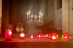 Blick auf den Altar mit dem Allerheiligsten und davor sind viele Kerzen